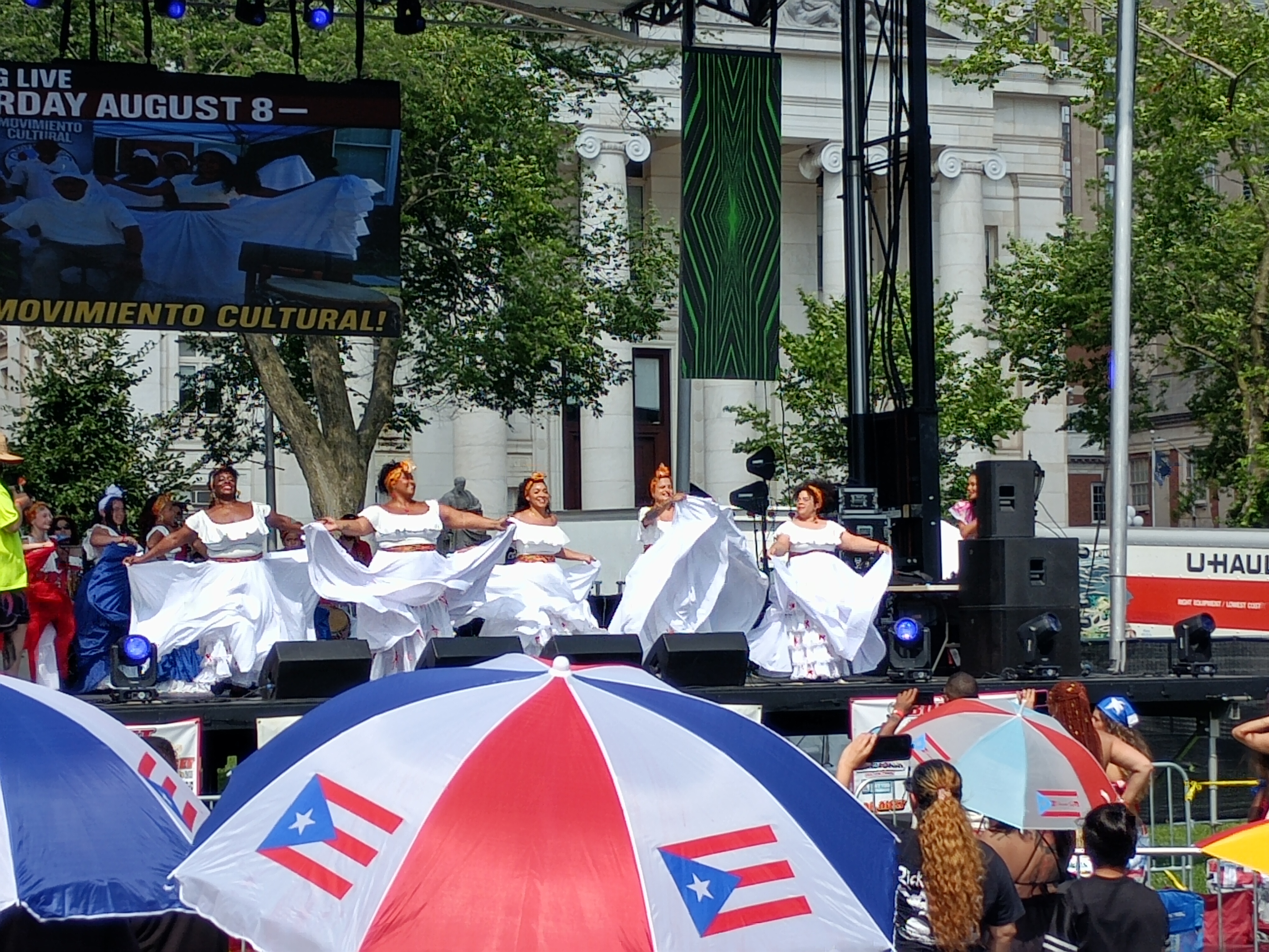 Bomba dancers in white skirts performing at the New Haven Puerto Rican parade, with Dean Carolina Dávila among them